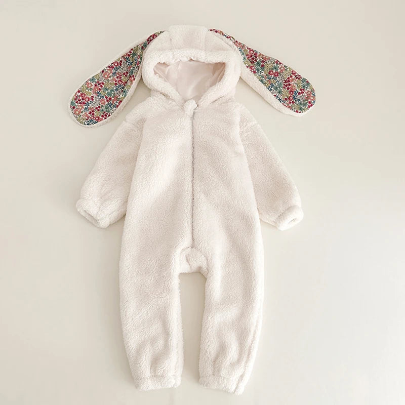 White baby snowsuit with floral bunny ears on a light background