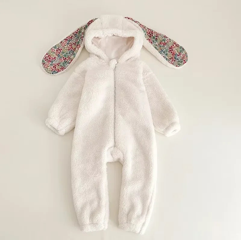 White baby snowsuit with floral bunny ears on a light gray background