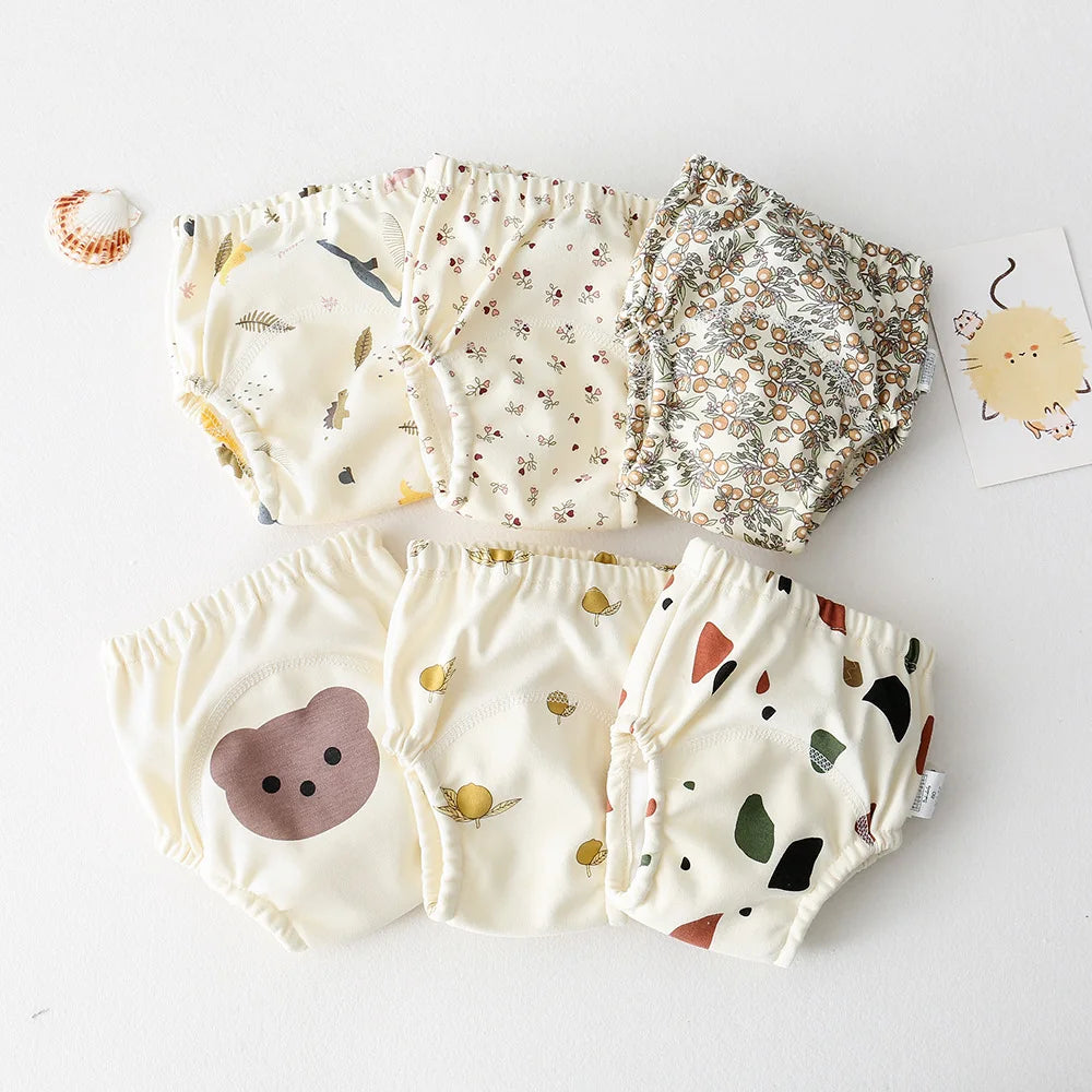 Collection of baby bloomers and a hat on a white background